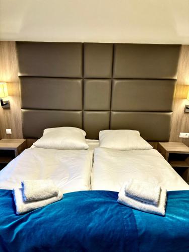 a large bed with two towels on top of it at Hotel Delicjusz in Trzebaw