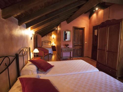 a bedroom with two beds in a room with beams at La Casona de Sobrepiedra in Sobrepiedra