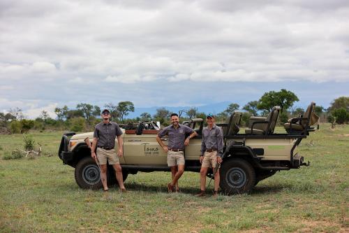 three men standing in front of a military vehicle at Tomo Safari Lodge in Hoedspruit