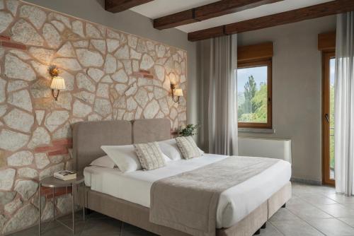 Un dormitorio con una cama grande y una pared de piedra. en Hotel Don Luis, en Castel di Sangro