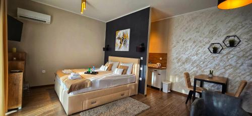 a bedroom with a large bed and a table at Annona Apartments in Bečej