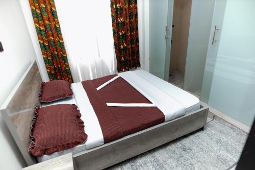 a small bed in a room with a window at MARA Apartments in Gisenyi
