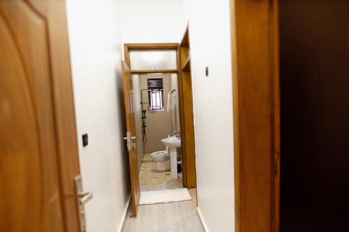a hallway of a bathroom with a toilet and a mirror at MARA Apartments in Gisenyi