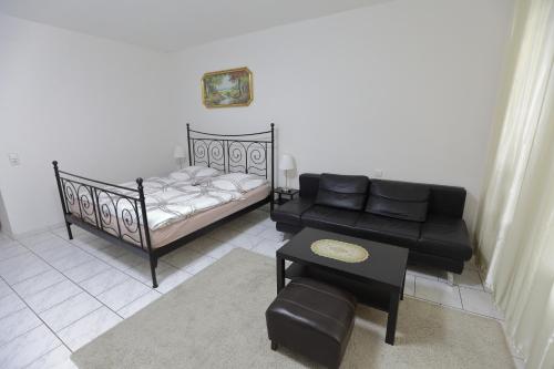 a living room with a couch and a bed at City Apartment 1 in Brühl