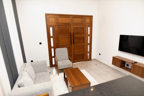 a living room with a couch and a tv at MARA Apartments in Gisenyi