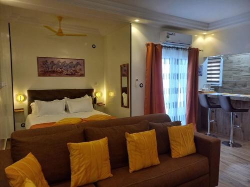 ein Wohnzimmer mit einer Couch und einem Bett in der Unterkunft Zebra Résidence in Bambilor