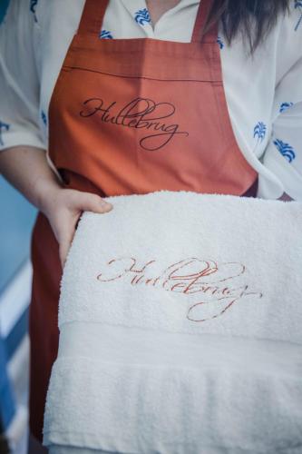 a woman wearing an apron with the words wedding anniversary written on it at B&B Hullebrug in Heist-op-den-Berg