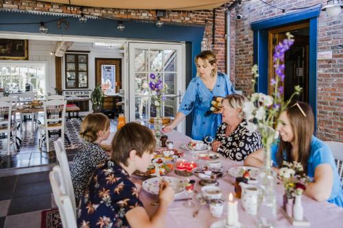 a group of people sitting around a table in a restaurant at B&B Hullebrug in Heist-op-den-Berg