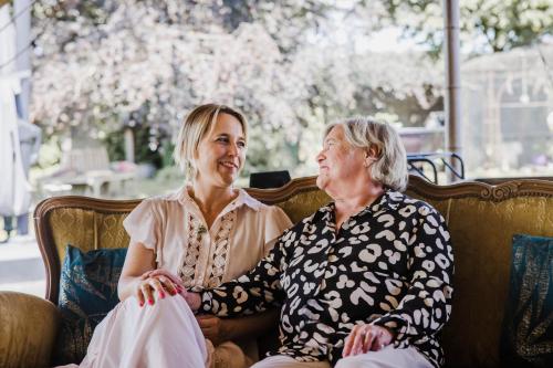 two older women sitting on a couch at B&B Hullebrug in Heist-op-den-Berg
