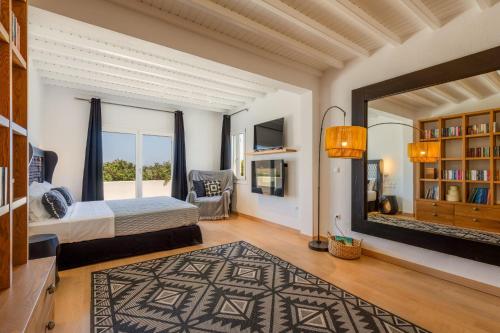 a bedroom with a bed and a large mirror at Myconian Platinum Senior & Deluxe Villas in Kalafatis