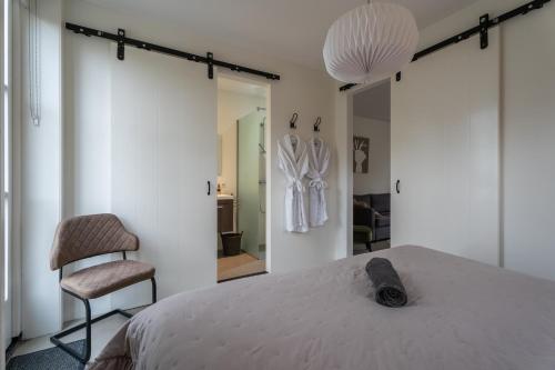 a bedroom with a bed and a chair at Hof Olmenstein in Goes