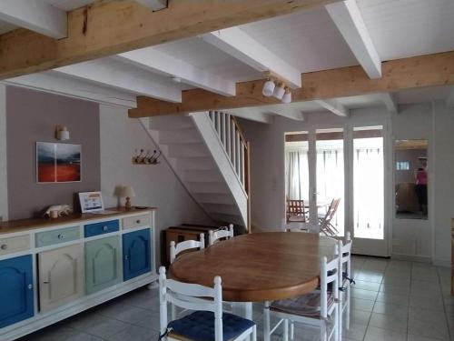 une cuisine et une salle à manger avec une table et des chaises en bois dans l'établissement Maison climatisée 4 pièces, 8 couchages, proche plage et commerces, avec véranda et barbecue - FR-1-229D-113, à Fleury