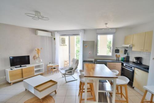 une cuisine avec une table et des chaises dans une pièce dans l'établissement Rives Du Lez avec terrasse et parking gratuit, à Montpellier