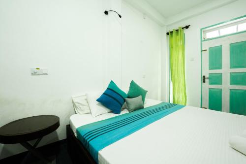 a bedroom with a bed and a table and a window at ceylonza in Kamburugamuwa