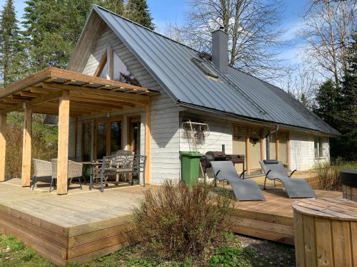 una casa con terraza con mesa y sillas en Mokko Saunahouse, en Änkküla