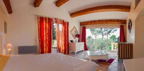 une chambre avec un lit et une grande fenêtre dans l'établissement Villa du Saignadou, à Tourtour