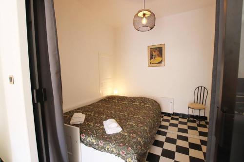 une petite chambre avec un lit et une chaise dans l'établissement Appartement de charme centre vieux village, à Villefranche-sur-Mer