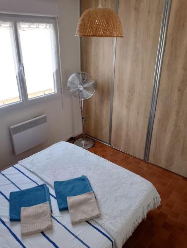 une chambre avec un lit avec deux serviettes dessus dans l'établissement Plage des Chalets, à Gruissan