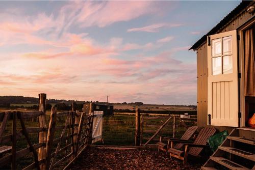 a house with a fence and chairs in a field at The Lookerer by Bloom Stays in Ashford