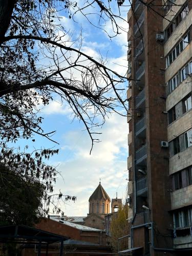 a building with a tower in the middle of two buildings at Mike in Yerevan