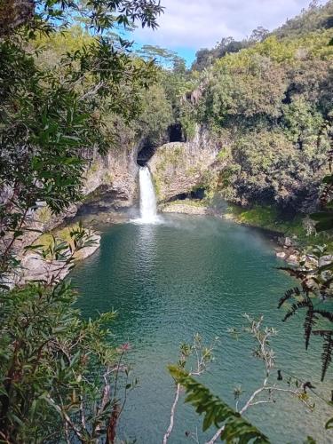 a waterfall in the middle of a pool of water at Bungalow L'escale de Takamaka in Saint-Benoît