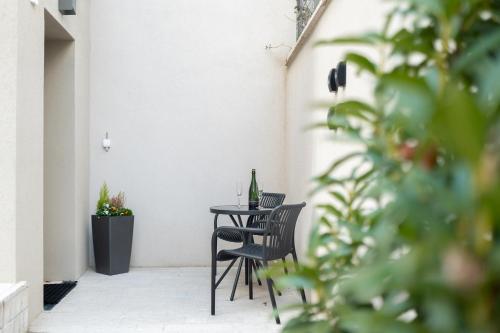 a table and chairs on a patio with a bottle of wine at Larum Balatonfüred - Adults only in Balatonfüred