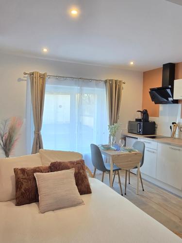 un salon avec un canapé et une table et une cuisine dans l'établissement S2 SWEET HOMES I Studio proche centre I Parking inclu, à Angoulême