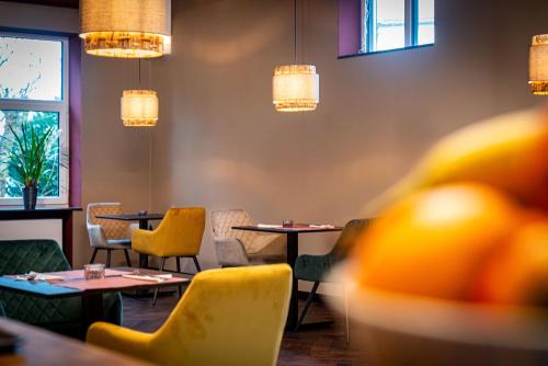 a restaurant with tables and chairs and lights at Hotel Parkzicht in Valkenburg