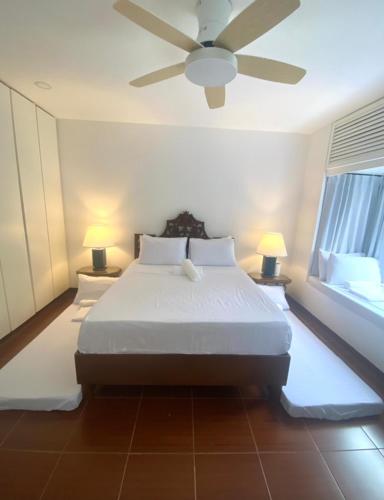 a bedroom with a bed with a ceiling fan at The Gallery House in Ulot