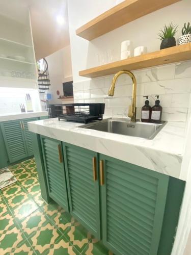 a kitchen with green cabinets and a sink at The Gallery House in Ulot