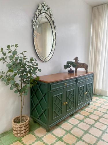 a green cabinet with a mirror and a potted plant at The Gallery House in Ulot