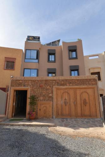 a building with two wooden garage doors in front of it at Tirazir House 3 in Mirleft
