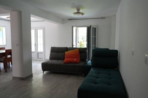 a living room with a black couch with a red pillow at Villa Orchidée- au coeur du centre-ville in LʼEntre-Deux