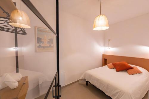 - une chambre avec un lit, deux lampes et un miroir dans l'établissement Charme et Modernité au coeur d'Aix & Cours Mirabeau, à Aix-en-Provence