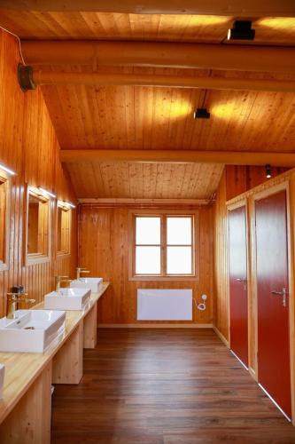 a bathroom with four sinks and a window at Trollforsen Camping & Cottages in Gargnäs