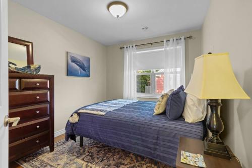 a bedroom with a bed with a lamp and a window at Freshwater Joys Jellybean 4br Gem In St John's in St. John's