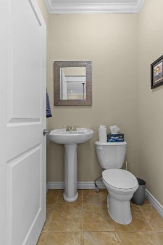 a bathroom with a white toilet and a sink at Freshwater Joys Jellybean 4br Gem In St John's in St. John's