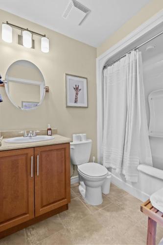 a bathroom with a toilet and a sink and a mirror at Freshwater Joys Jellybean 4br Gem In St John's in St. John's