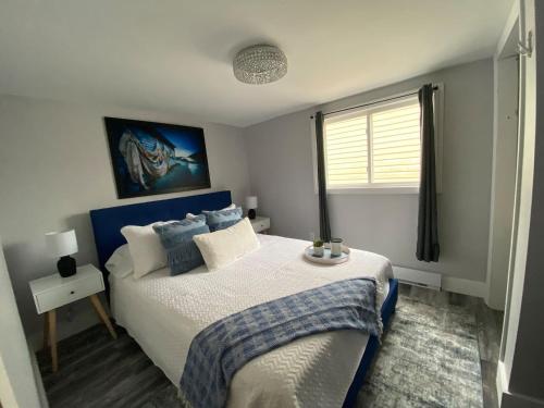 a bedroom with a large bed and a window at Adventure Haven Hot Tub & Quidi Vidi Charm in St. John's