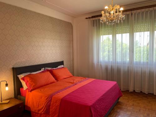a bedroom with a large bed and a chandelier at Nostro Rifugio Vacanza in Brugnera