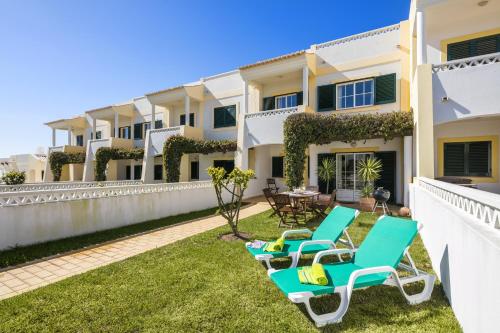 a patio with chairs and tables in front of a house at 11 Terracos de Benagil - Casa Paraiso in Benagil