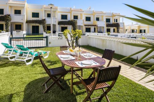 a patio with a table and chairs on the grass at 11 Terracos de Benagil - Casa Paraiso in Benagil