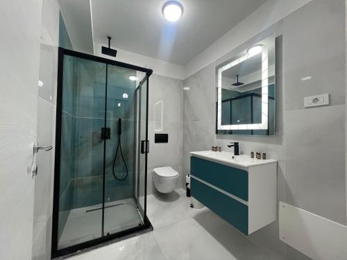 a bathroom with a shower and a sink and a toilet at Moft Apartment by White Titanic in Mamaia Nord