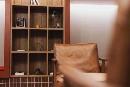 a chair in a room with a book shelf at GEMS YUFUIN Hotel and Spa Cafe Bar in Yufuin