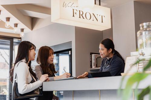 a group of people standing around a store counter at GEMS YUFUIN Hotel and Spa Cafe Bar in Yufuin