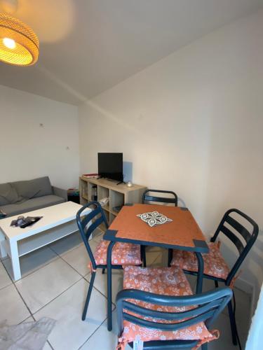 a table and chairs in a living room with a couch at Duplex quartier calme et parking gratuit in Amiens