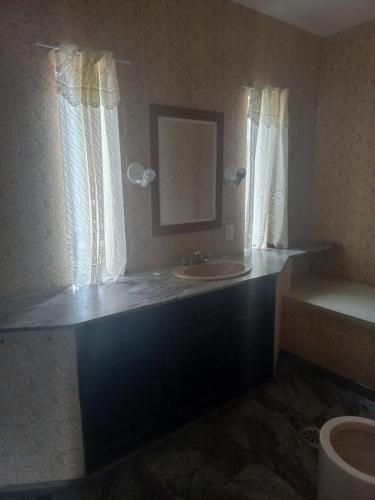 a bathroom with a sink and a mirror at Pousada Rota do Sol in Cabo Frio