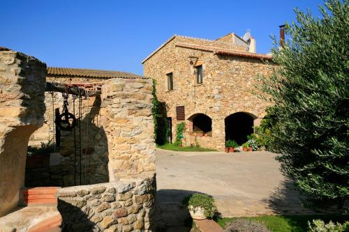 un gran edificio de piedra con entrada a un patio en Can Barrull, en Sant Feliu de Boada