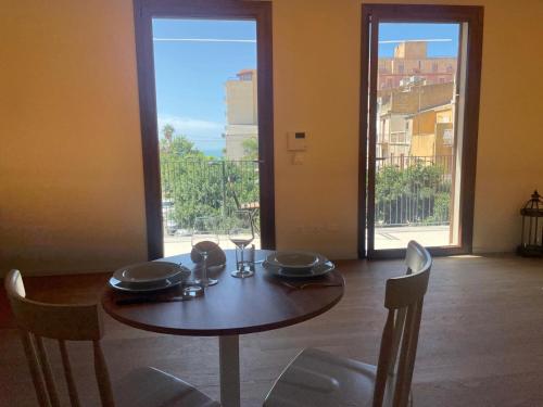 a dining room table with chairs and a table and a window at Casa faro in Realmonte