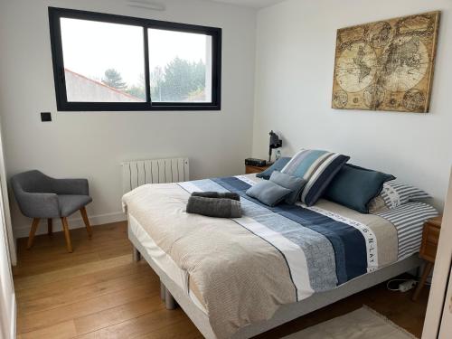 une chambre avec un lit, une fenêtre et une chaise dans l'établissement Petit appartement mitoyen, à Royan